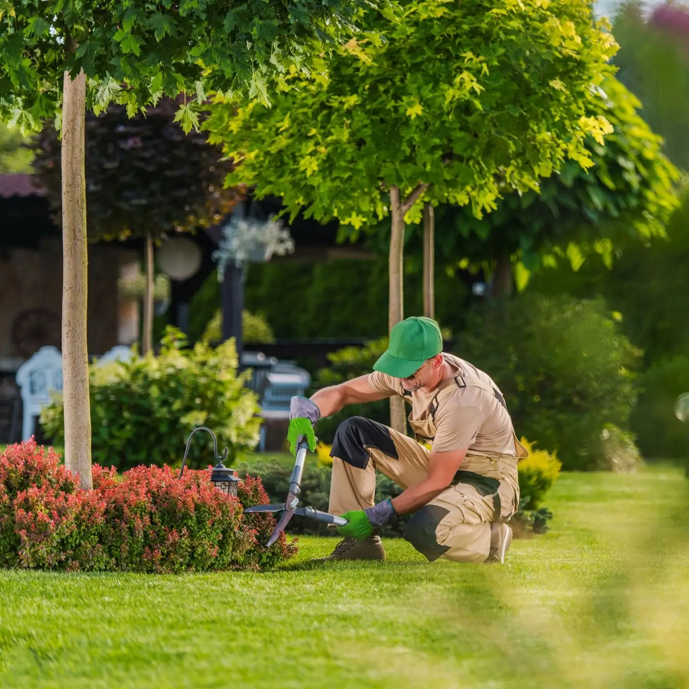 landscaper trimming small hedges, providing maintenance free living at the Moore