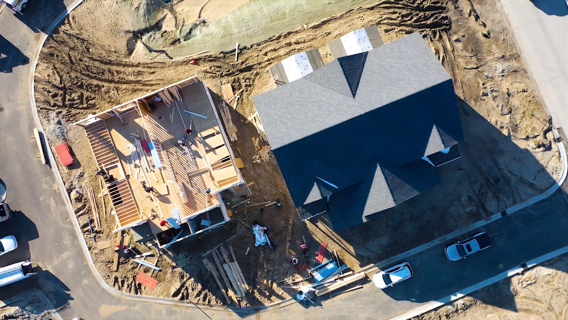 Drone shot of workers building at The Moore for construction update video and article about properties townhomes now selling near Lake Michigan