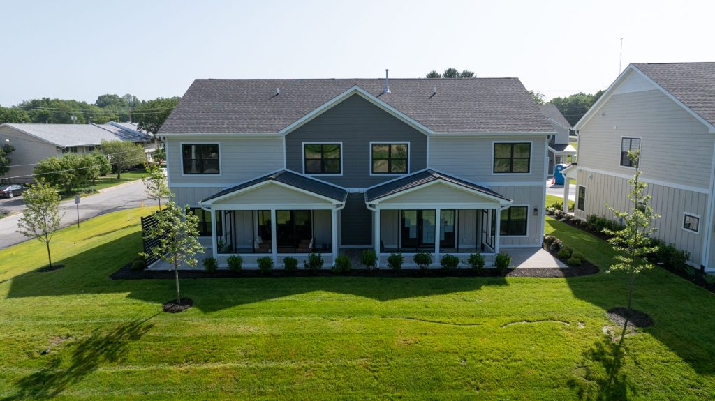 11 and 13 Moorebrooke Rd Michigan City, IN The Dunehaven Model Home duplex townhome back exterior drone shot with 3-seasons room and patio